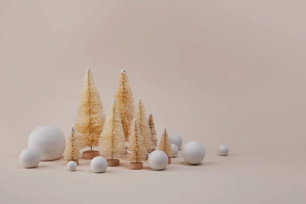 Arbres de Noël dorés avec boule de neige sur fond de siège. Concept minimal pour les journées hollandaises d'hiver. — Photo