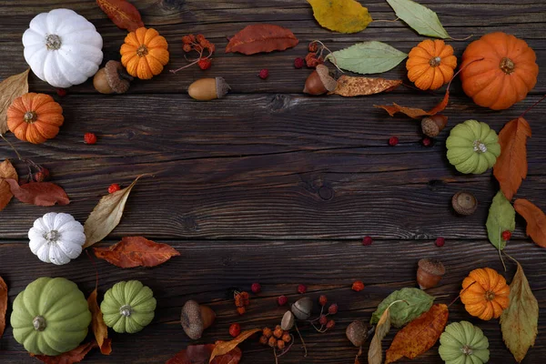 Erntedank- oder Erntedank-Hintergrund mit Kürbissen und Herbstblättern auf rustikalem Holzgrund — Stockfoto