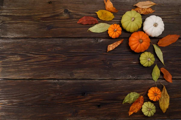 Ação de graças ou fundo de colheita com abóboras e folhas de outono em fundo de madeira rústica — Fotografia de Stock