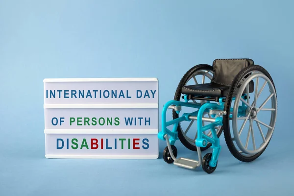 International day of persons with disabilities. Wheelchair on blue background. — Stock Photo, Image