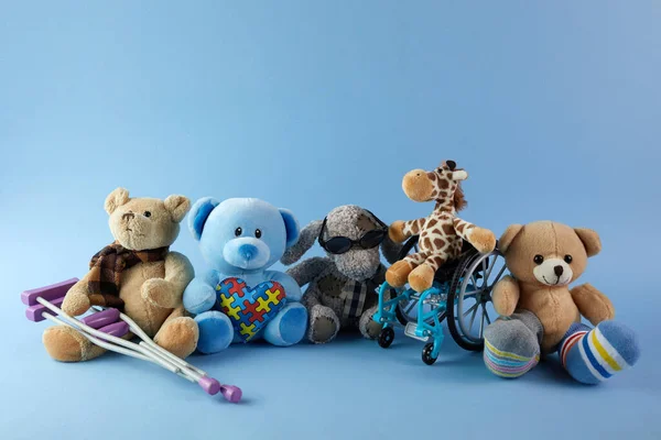 International day of persons with disabilities. Wheelchair with toys sign of different disabilities on blue background. — Stock Photo, Image