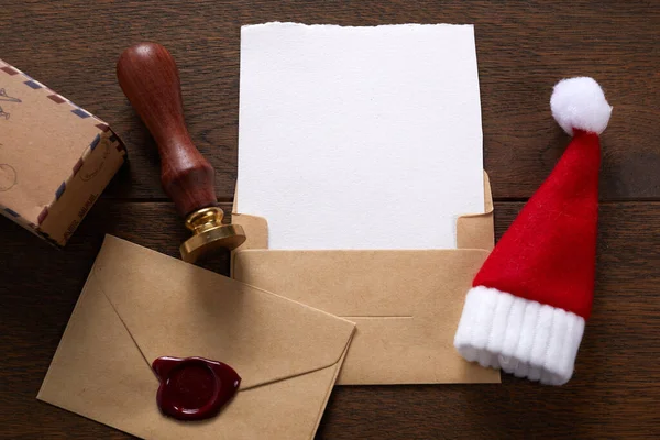 在木制桌子上摆满圣诞装饰品的空荡荡的圣诞老人愿望清单。顶部视图. — 图库照片