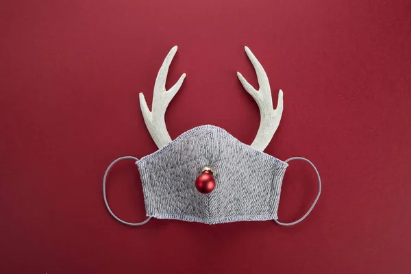 Reindeer horns with face mask and red ball. Pandemic Christmas concept. Flat lay. — Stock Photo, Image