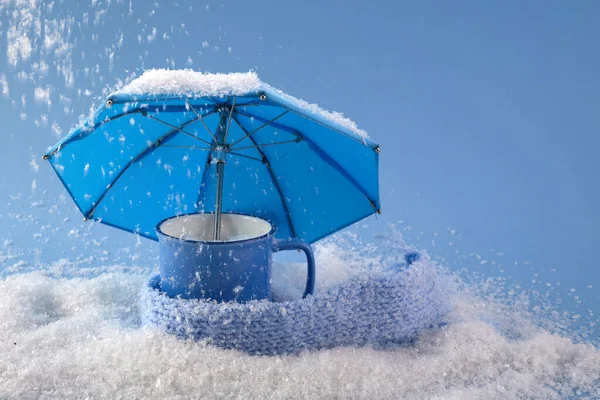 Blå paraply och kopp kaffe på blå bakgrund med snö. Blå måndagskoncept. — Stockfoto