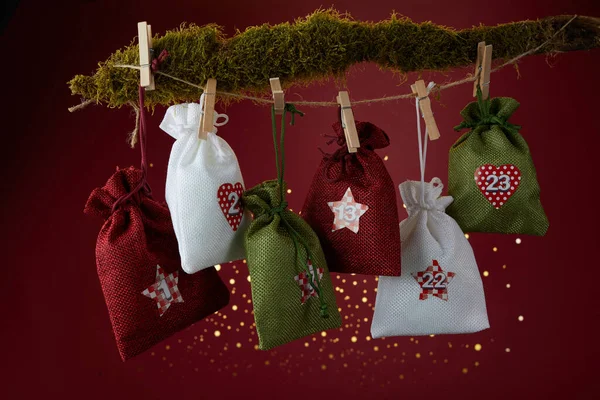 Adventní kalendář s překvapením pro Vánoce na červeném pozadí — Stock fotografie