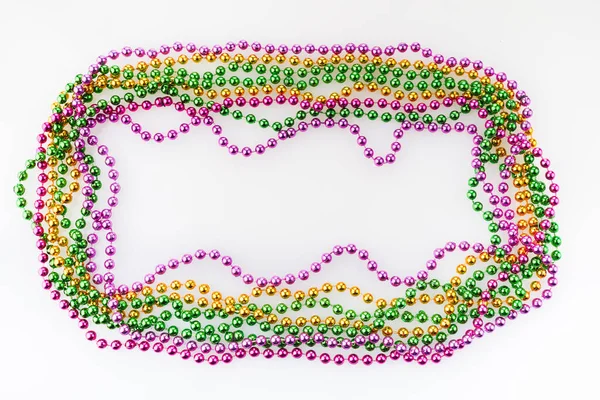 Tre colori Mardi gras cornice perline su sfondo bianco — Foto Stock