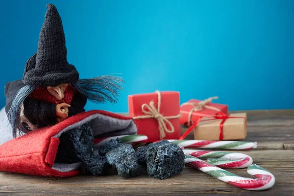 O Befana com carvão doce e doces em fundo de madeira. Italiano tradição dia Epifania. — Fotografia de Stock