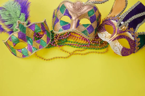 黄色の背景にビーズとマルディグラやカーニバルマスク。ベネチアンマスク. — ストック写真