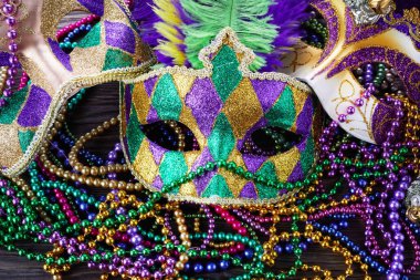 Bir grup Venedikli ve New Orlean Mardi Gras maskesi koyu arkaplanda renkli boncuklarla