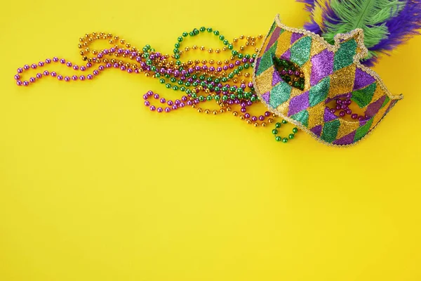 Mardi gras nebo karnevalová maska s korálky na žlutém pozadí. Benátská maska. — Stock fotografie