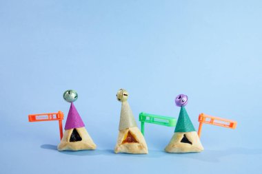 Purim kutlaması konsepti. Geleneksel Hamantashen kurabiyeleri ve palyaço şapkası..