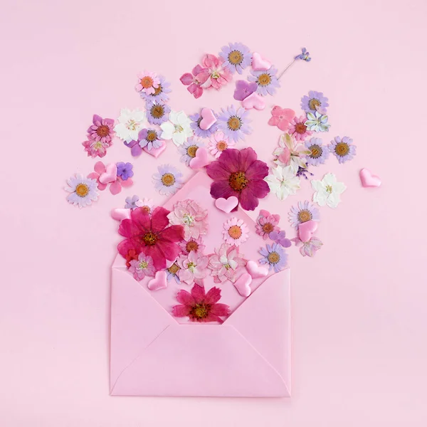 Busta con fiori colorati selvatici su sfondo rosa. Concetto d'amore. Posa piatta. — Foto Stock