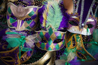 Bir grup Venedikli ve New Orlean Mardi Gras maskesi koyu arkaplanda renkli boncuklarla