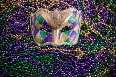 Bir grup Venedikli ve New Orlean Mardi Gras maskesi koyu arkaplanda renkli boncuklarla