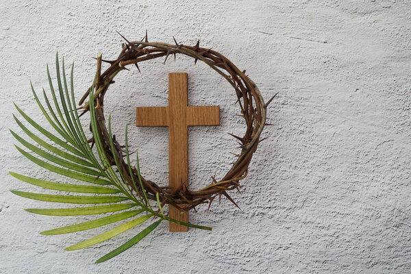 Palm sunday background. Cross and palm on grey background.