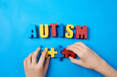 Otistik çocuk elleri yapboz, kelime otizmi, akıl sağlığı konsepti. Otizm spektrumu, düzensizlik. Dünya Otizm Farkındalık Günü.