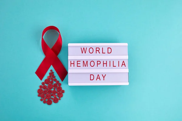 Awareness oncept with blood drop and red ribbon. World Hamophilia day or blood donor day. — Stock Photo, Image