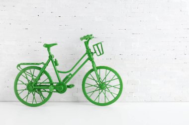 Dünya bisiklet günü konsepti. Beyaz tuğla duvarda yeşil bisiklet. 3 Haziran.