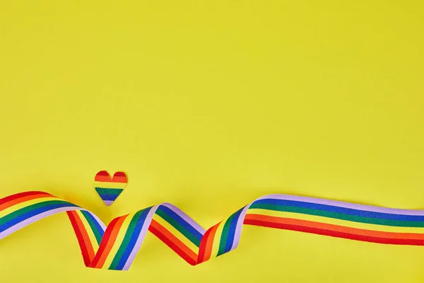 Осознание гордости ЛГБТ-сообщества за радужную ленту на желтом фоне. — стоковое фото