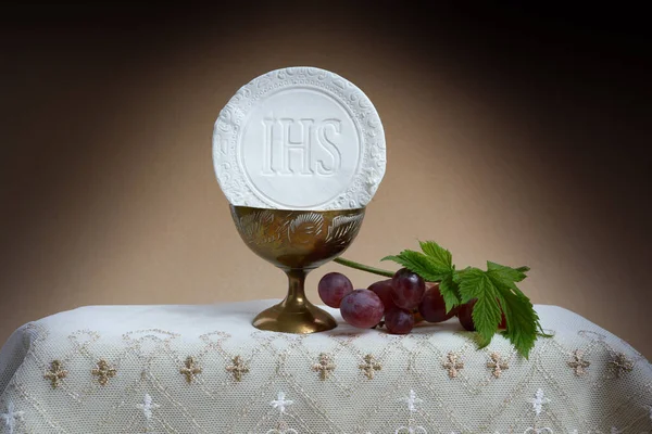 Het feest van Corpus Christi Concept. Heilige communie en kopje glas met rode wijn op tafel. — Stockfoto