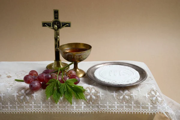 Svátek Corpus Christi Concept. Svaté přijímání a šálek skla s červeným vínem na stole. — Stock fotografie