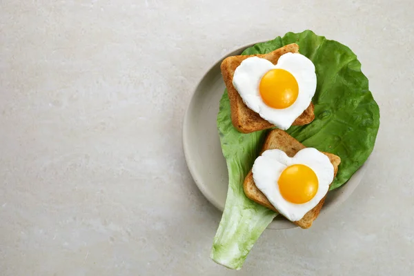 Œuf en forme de cœur dans une tranche de pain de seigle en céramique. J'adore le design petit déjeuner. Un sandwich sain. Déjeuner ou petit déjeuner festif. Jour des oeufs. — Photo
