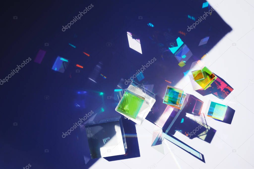 Abstract background with glass geometric figures prisms with light diffraction of spectrum colors and complex reflection.