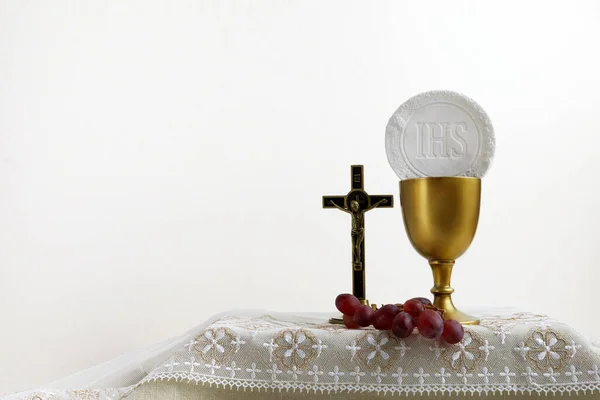 The Feast of Corpus Christi Concept. Holy communion and cup of glass with red wine on table. — Stock Photo, Image