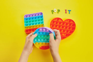 Çocuk elleri renkli şekerlemelerle oynuyordu. Renkli anti-stres oyuncağı. Kıpırda, kıpırda, kıpırda..