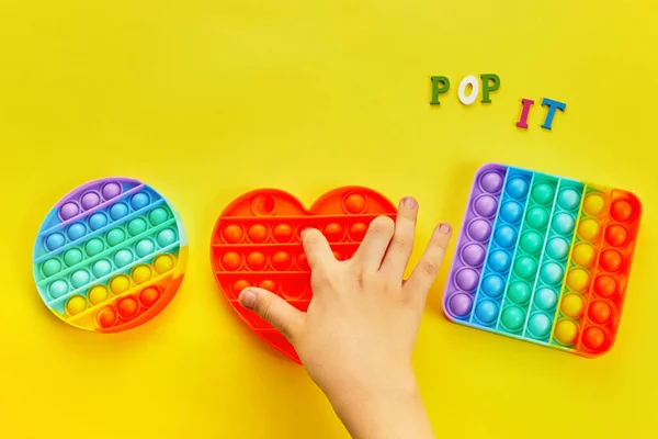 Çocuk elleri renkli şekerlemelerle oynuyordu. Renkli anti-stres oyuncağı. Kıpırda, kıpırda, kıpırda.. — Stok fotoğraf