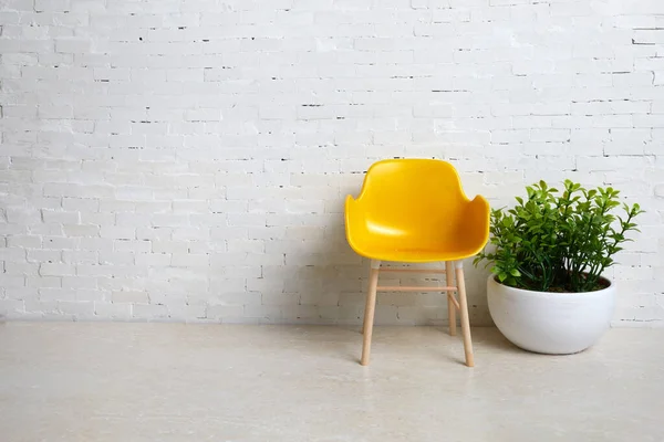 Kursi kuning di latar belakang dinding bata putih. Interior sederhana. — Stok Foto