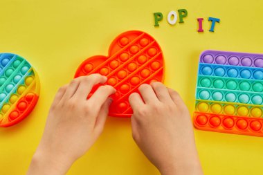 Çocuk elleri renkli şekerlemelerle oynuyordu. Renkli anti-stres oyuncağı. Kıpırda, kıpırda, kıpırda..