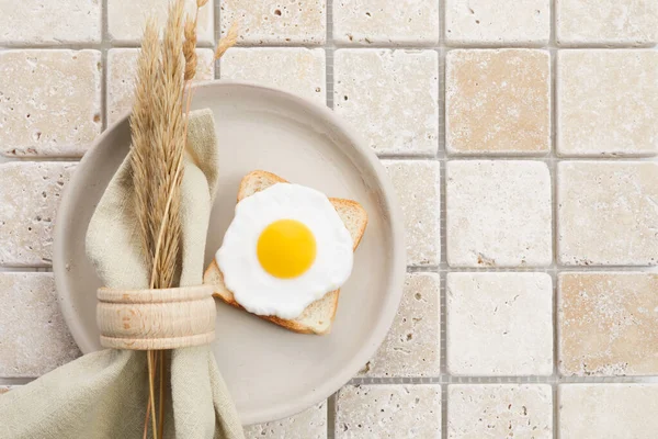 Snygg servering på en travertin mosaik bakgrund. Linneservetter och ägg på tallriken. Ovanifrån — Stockfoto