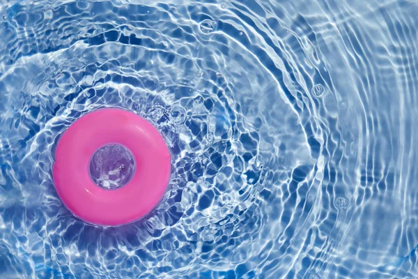 Anello galleggiante piscina rosa galleggiante in una piscina blu rinfrescante. Vista dall'alto — Foto Stock