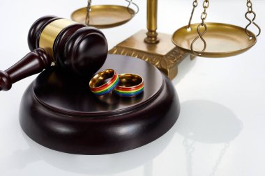 Igbt gökkuşağı renginde iki altın alyans. Homoseksüel evlilik. Lgbt hakları ve hukuku.