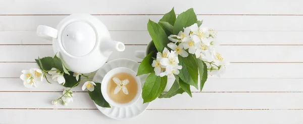 茉莉花和茶壶在白色木制背景。茉莉花草药茶。平躺在床上. — 图库照片