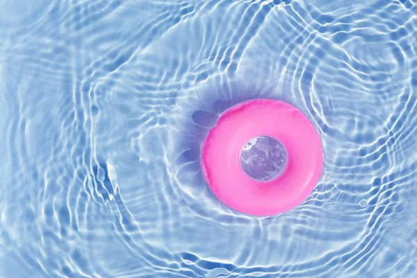 Pink pool float ring floating in a refreshing blue swimming pool. Top view — Stock Photo, Image