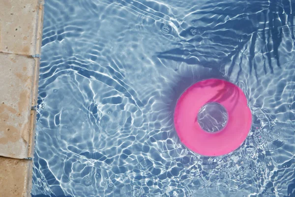 Pink pool cincin mengambang di kolam renang biru menyegarkan. Tampilan atas — Stok Foto