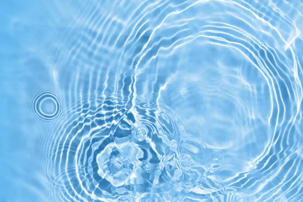 Desfocado transparente azul colorido textura de superfície de água clara. Ondas de água na luz solar. — Fotografia de Stock