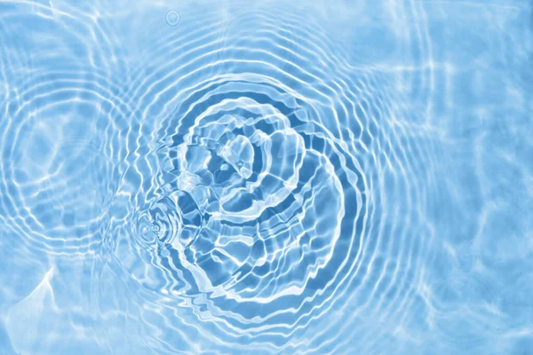 Sfocato trasparente azzurro colore trasparente superficie dell'acqua texture. Onde d'acqua alla luce del sole. — Foto Stock