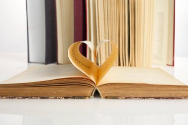 Ulusal Kitap Aşıkları Günü. 9 Ağustos. Kitap açılır ve kitap sayfası kalbe doğru yuvarlanır.