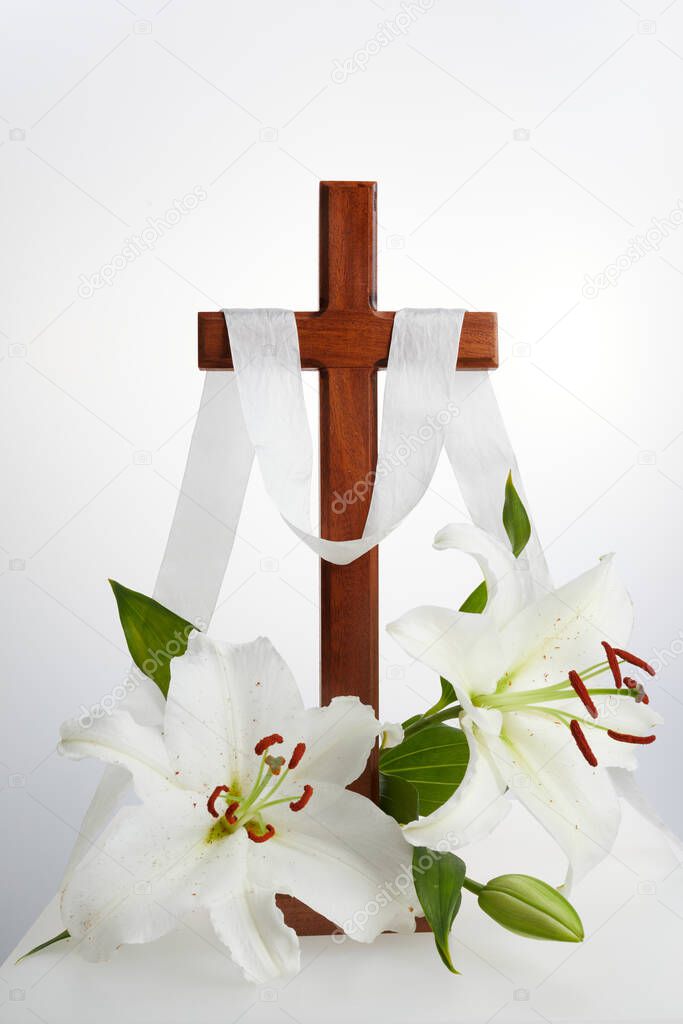 Cross with lilies on white background. Spring background. Easter, baptism or first communion concept
