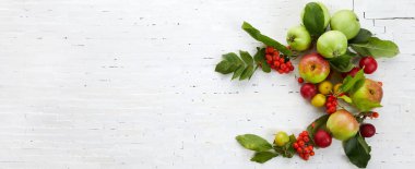 Sonbahar sarısı, turuncu ve kırmızı sebzeler ve beyaz tuğla duvar zemininde meyveler, üst manzara, düz yatış. Sonbahar arkaplanı.