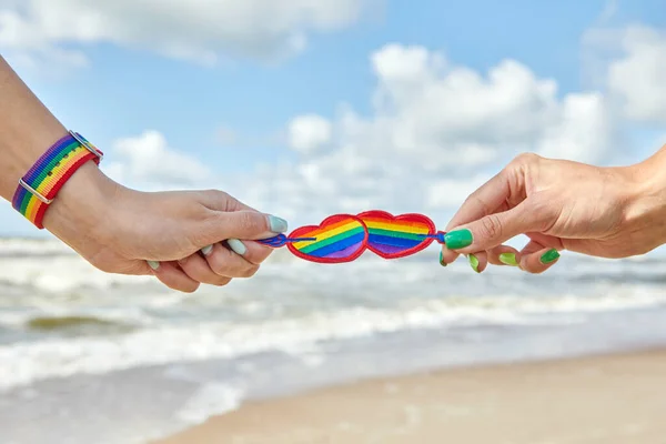 Радужные сердца ЛГБТК символ любви, две женские пары рук, любовники — стоковое фото