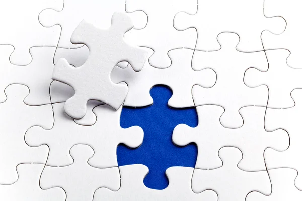 Plain white jigsaw puzzle, on Blue background — Stock Photo, Image