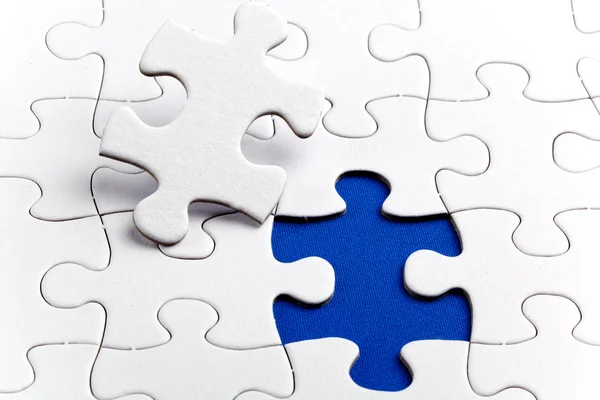 Plain white jigsaw puzzle, on Blue background — Stock Photo, Image