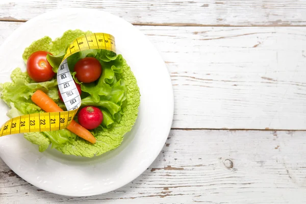 Green salad with measuring tape — Stock Photo, Image