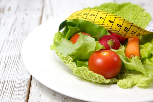 Green salad with measuring tape — Stock Photo, Image