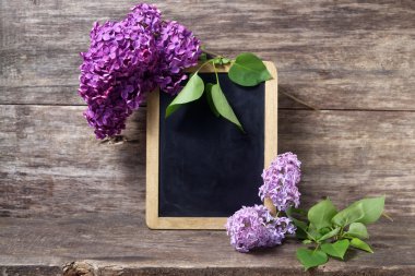  Lila çiçek vazo ve yazı tahtası 