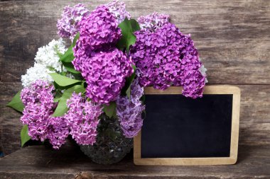  Lila çiçek vazo ve yazı tahtası 